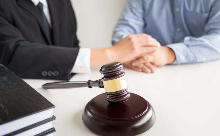 Tips for Choosing a Criminal Defense Attorney in Fresno - gavel on table with attorney and client sitting at table together