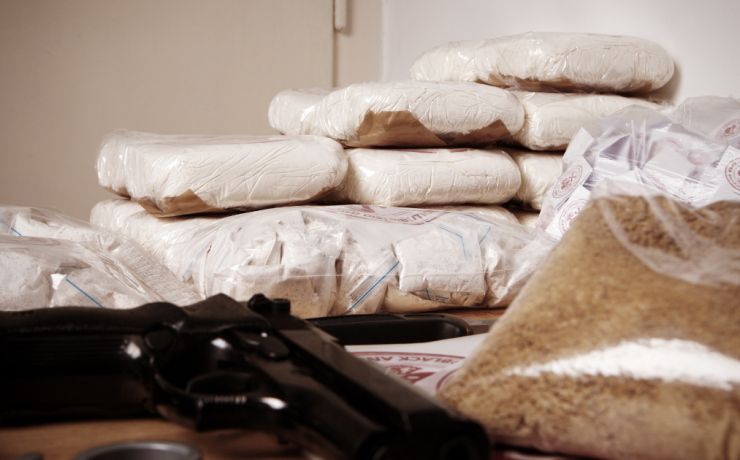When Does Possession Turn Into a Charge of Drug Trafficking? drug packages and gun on table