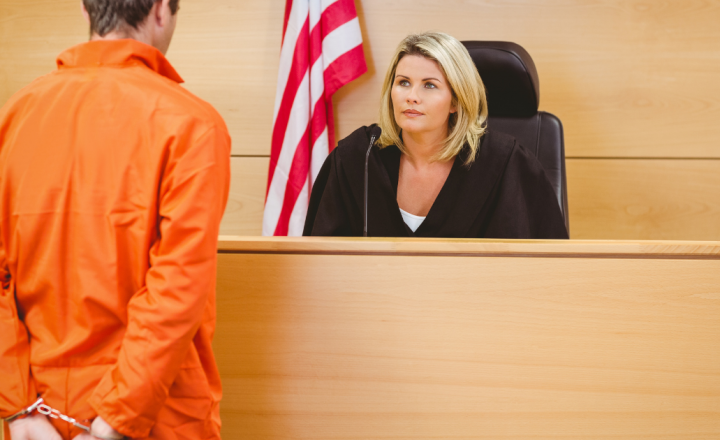 How This New California Law Can Reduce Sentencing Post Conviction - convicted defendant in orange jumpsuit speaking to judge at bench in front of courtroom
