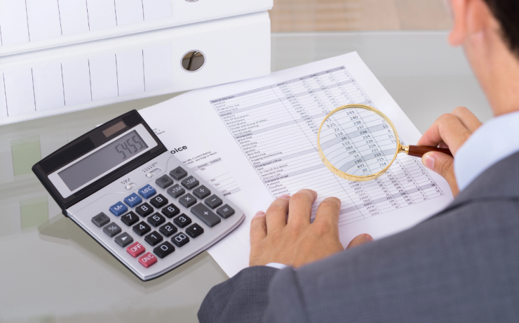 What is a Ponzi Scheme? auditor investigating fraud with magnifying glass