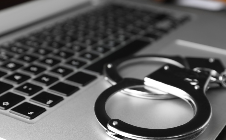 I've Been Charged with Cyber Crime, What Do I Do Next? - closeup of handcuffs on laptop