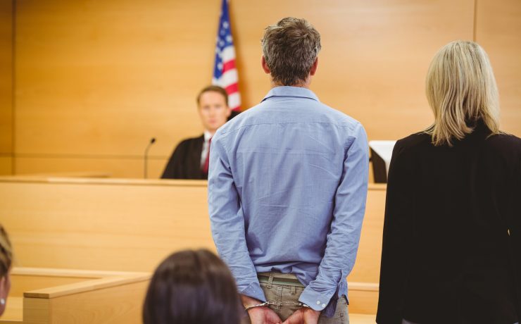 What Happens After a Felony Arrest in California? A lawyer and defendant stand before a judge in a courtroom.